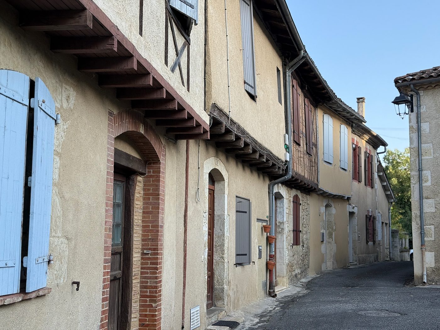 Photographie de Pessan — Une rue aux maisons à pans de bois et aux volets bleus