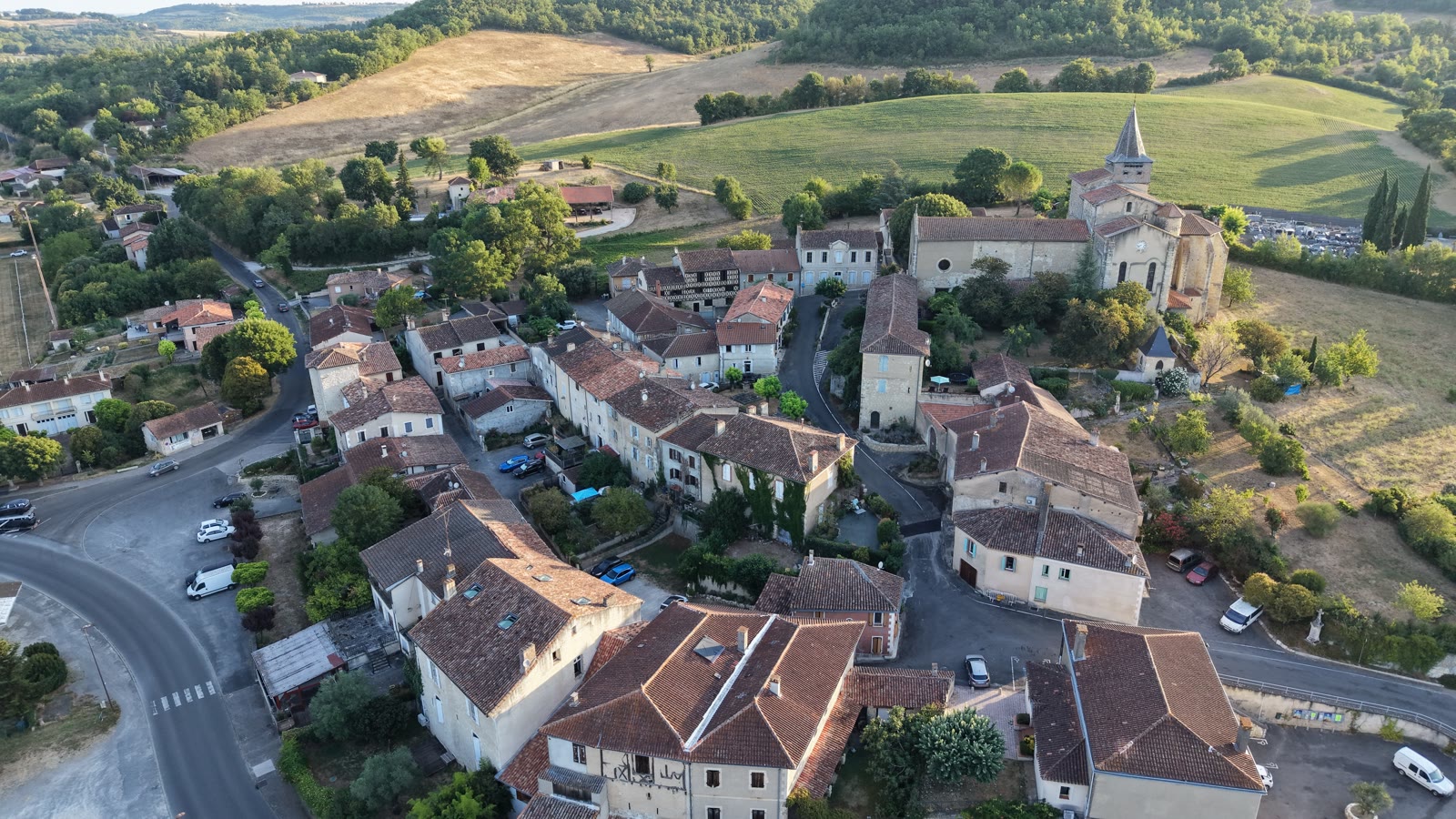 Vue aérienne du cœur de Pessan : les toits du village et l'église Saint-Michel